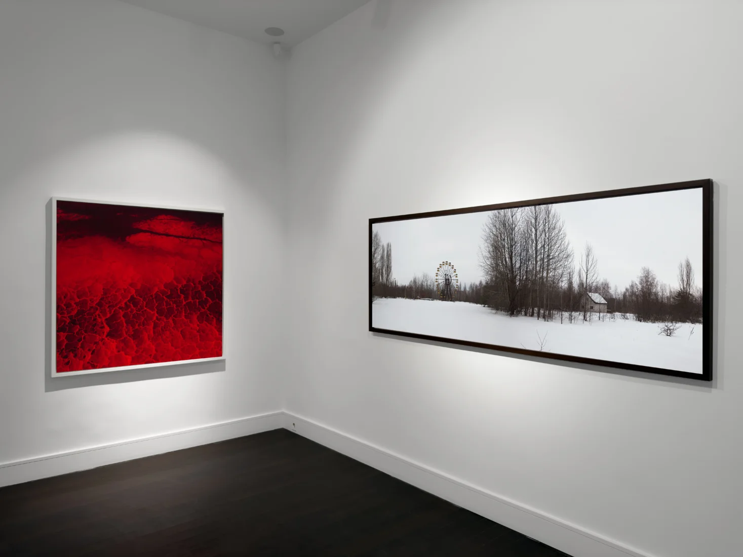 Vision Art Platform'daki Lightscapes sergisinden Charles-Joseph de Ligne'in büyük boyutlu, çerçevesiz bir fotoğrafı; izleyicinin siluetini ve mekânın ışığını kendi içine çeken parlak yüzeyinde, karanlık ve dönen kozmik imgelerle algının değişkenliğini vurguluyor.